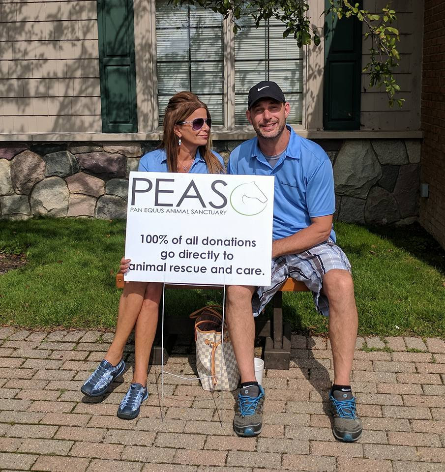 The Bridal Merchant Services family holding a Pan Equus Animal Sanctuary donation sign